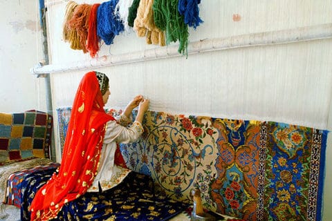 Donna lavora su telaio per tappeti.