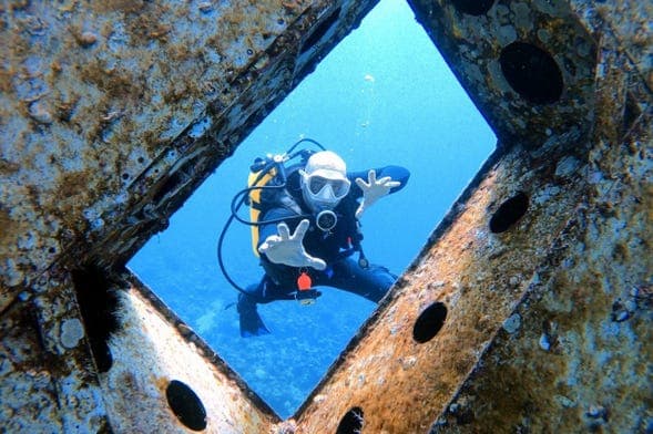 Subacqueo esplora relitto marino.