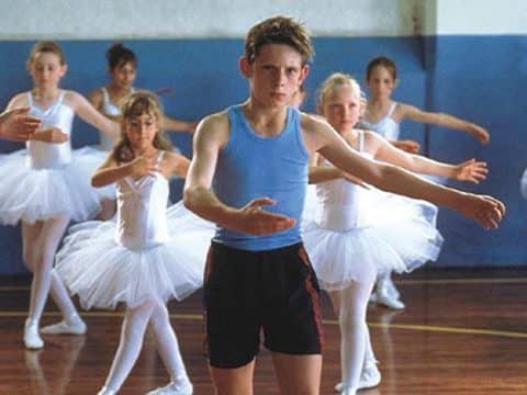 Ragazzo in lezione di danza con ballerine.
