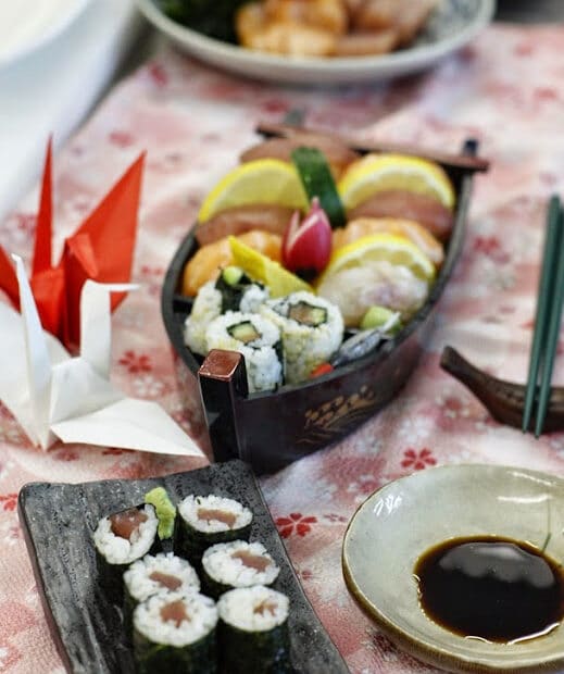 Barchetta sushi e origami su tavolo.