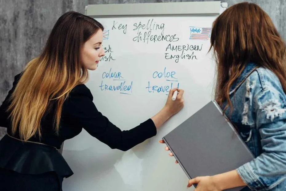 Due persone confrontano ortografia inglese su lavagna.