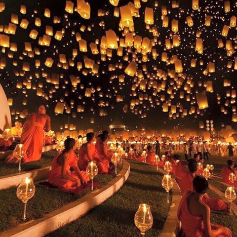 Lanterne volanti e monaci in preghiera di notte.