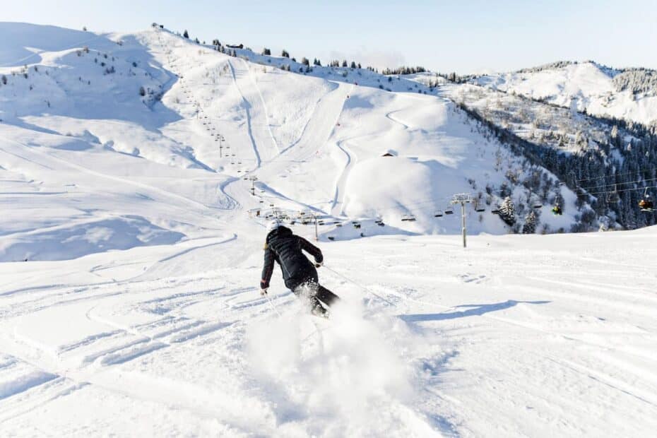 Snowboarder scende pista innevata in montagna.