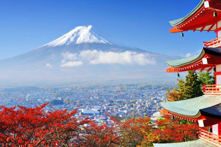 Monte Fuji con tempio e foglie rosse in primo piano.