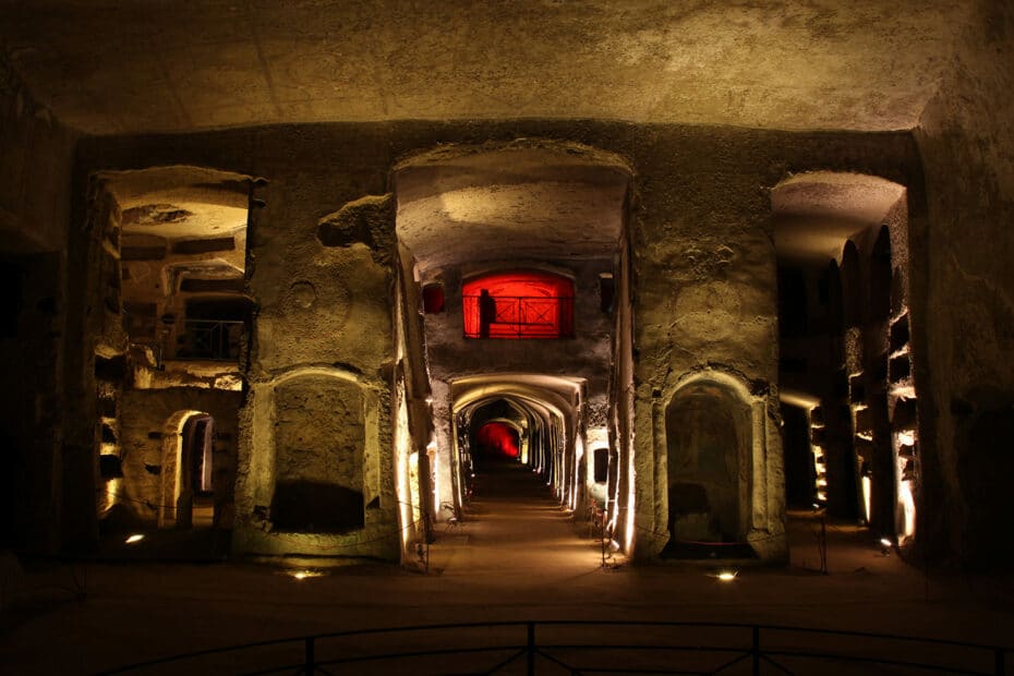 Corridoio illuminato in antica catacomba sotterranea.