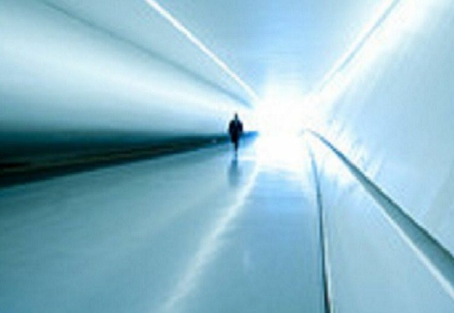Persona cammina verso luce in corridoio futuristico