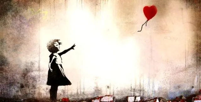 Bambina rilascia palloncino a forma di cuore.