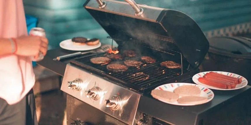 Barbecue estivo con hamburger e salsicce.