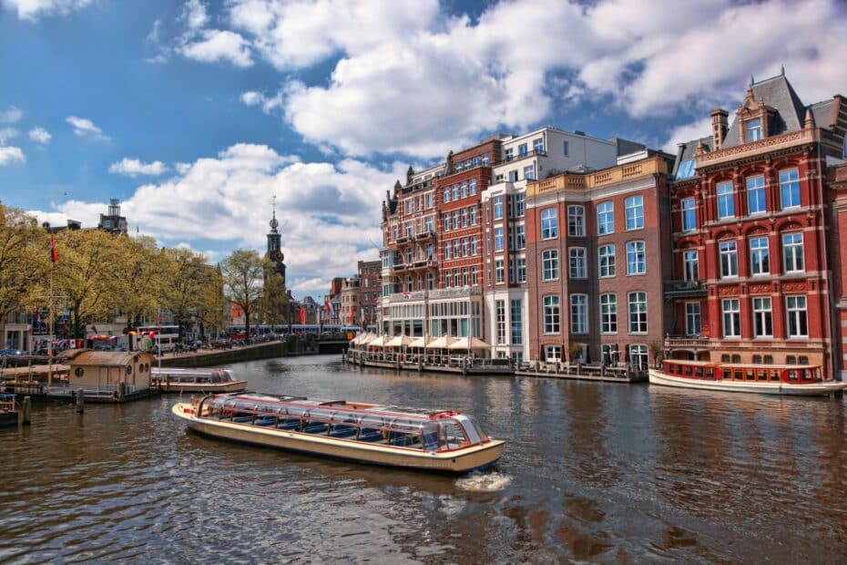 Canale di Amsterdam con barca turistica e edifici storici.