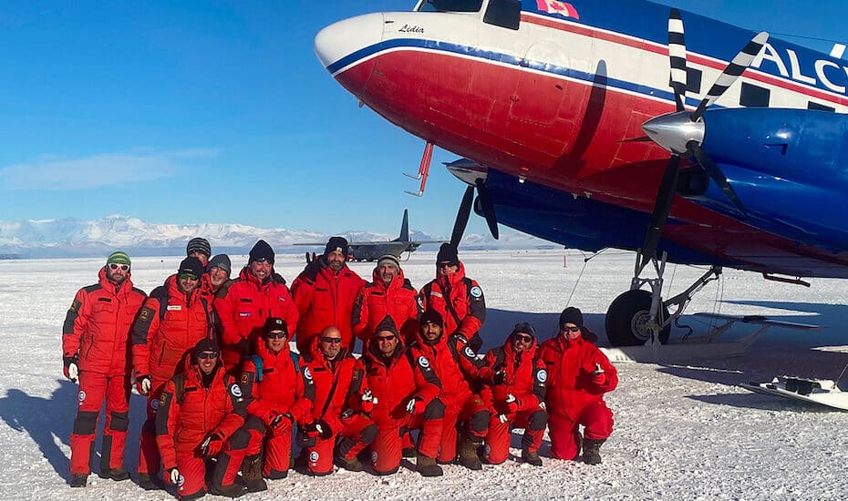 Gruppo di esploratori in Antartide con aereo.
