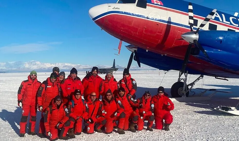Gruppo di esploratori in Antartide con aereo.