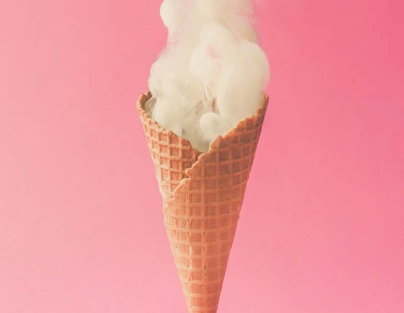 Cono gelato con fumo su sfondo rosa.