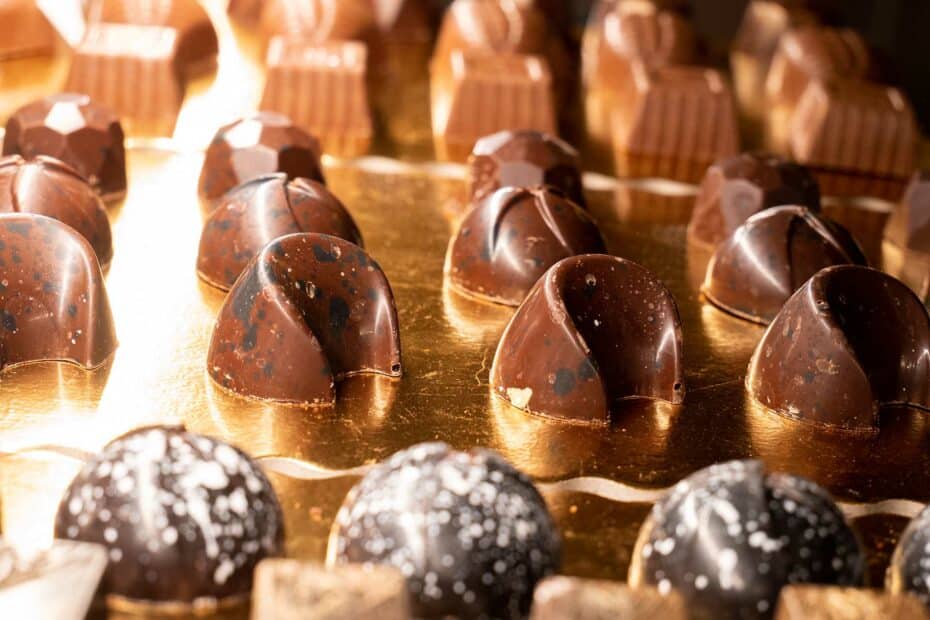Cioccolatini artigianali su vassoio dorato.