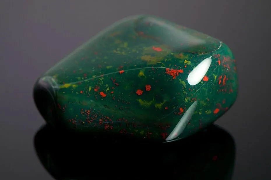 Pietra preziosa verde con riflessi rossi.