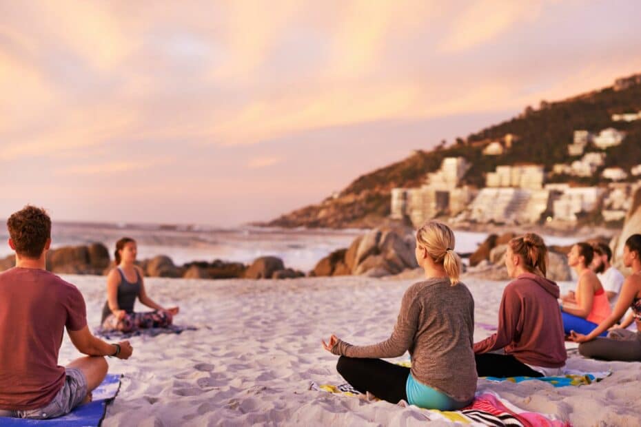 Lezione di yoga sulla spiaggia al tramonto.