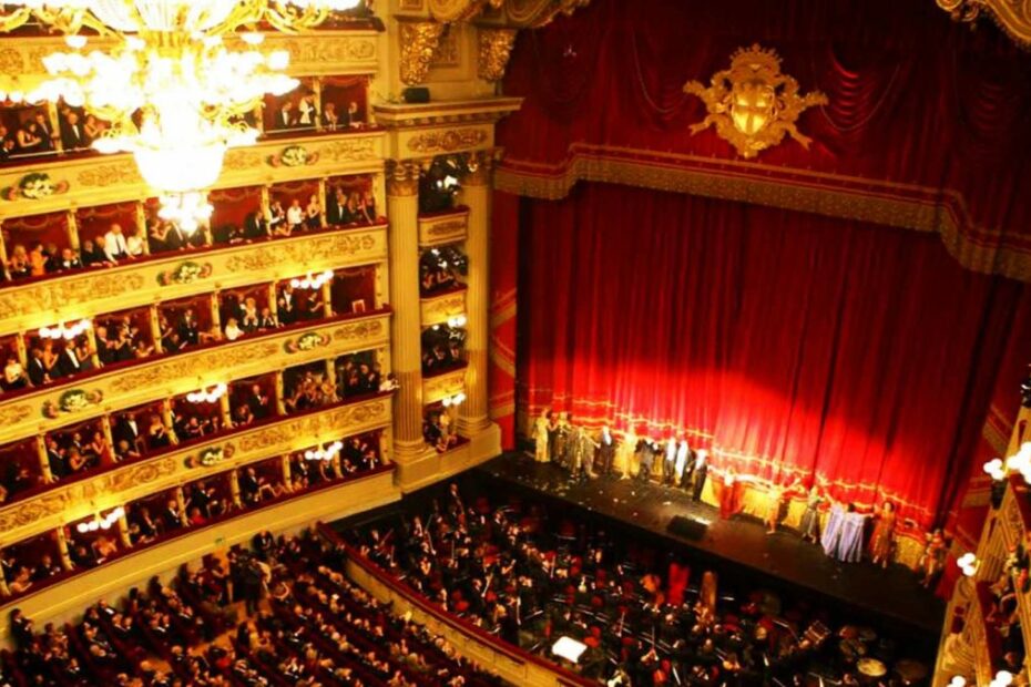 Interni teatro elegante con palcoscenico e pubblico.