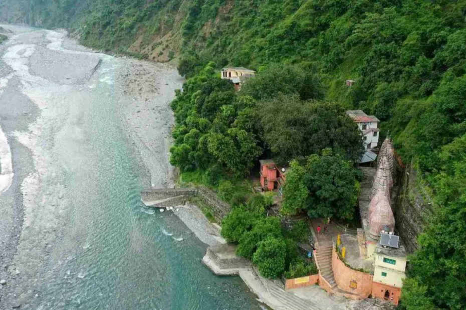 Fiume tortuoso e case tra le colline verdi.