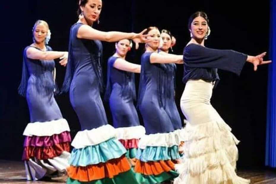 Gruppo di ballerine esegue danza flamenco sul palco.