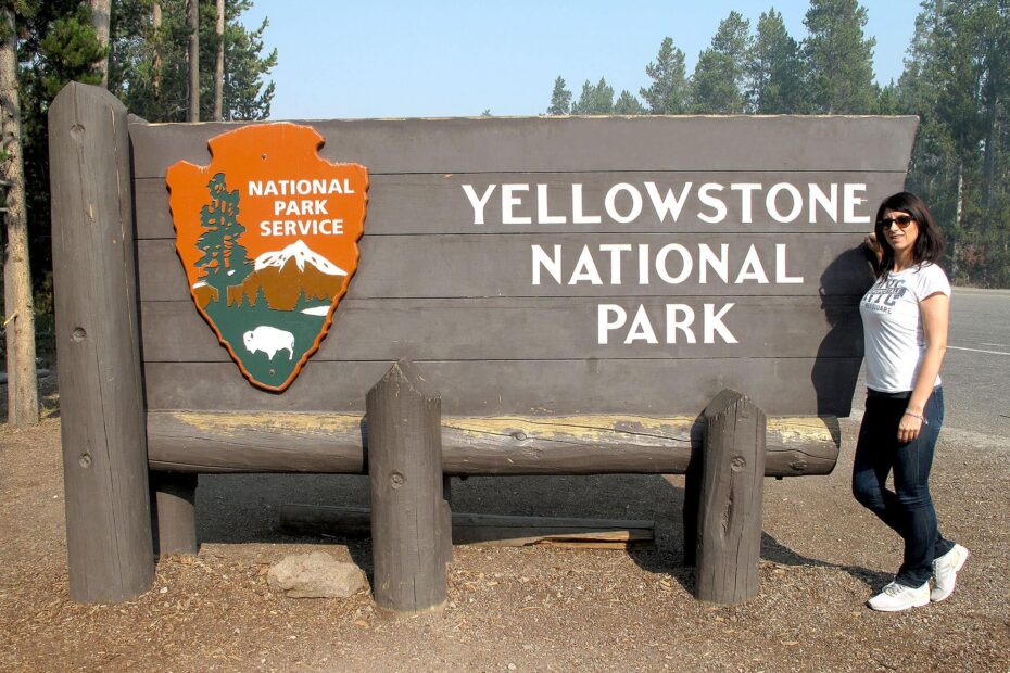 Turista al cartello di Yellowstone National Park.