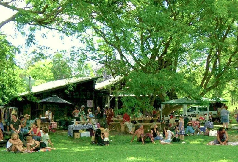 Mercatino all'aperto sotto gli alberi verdi.